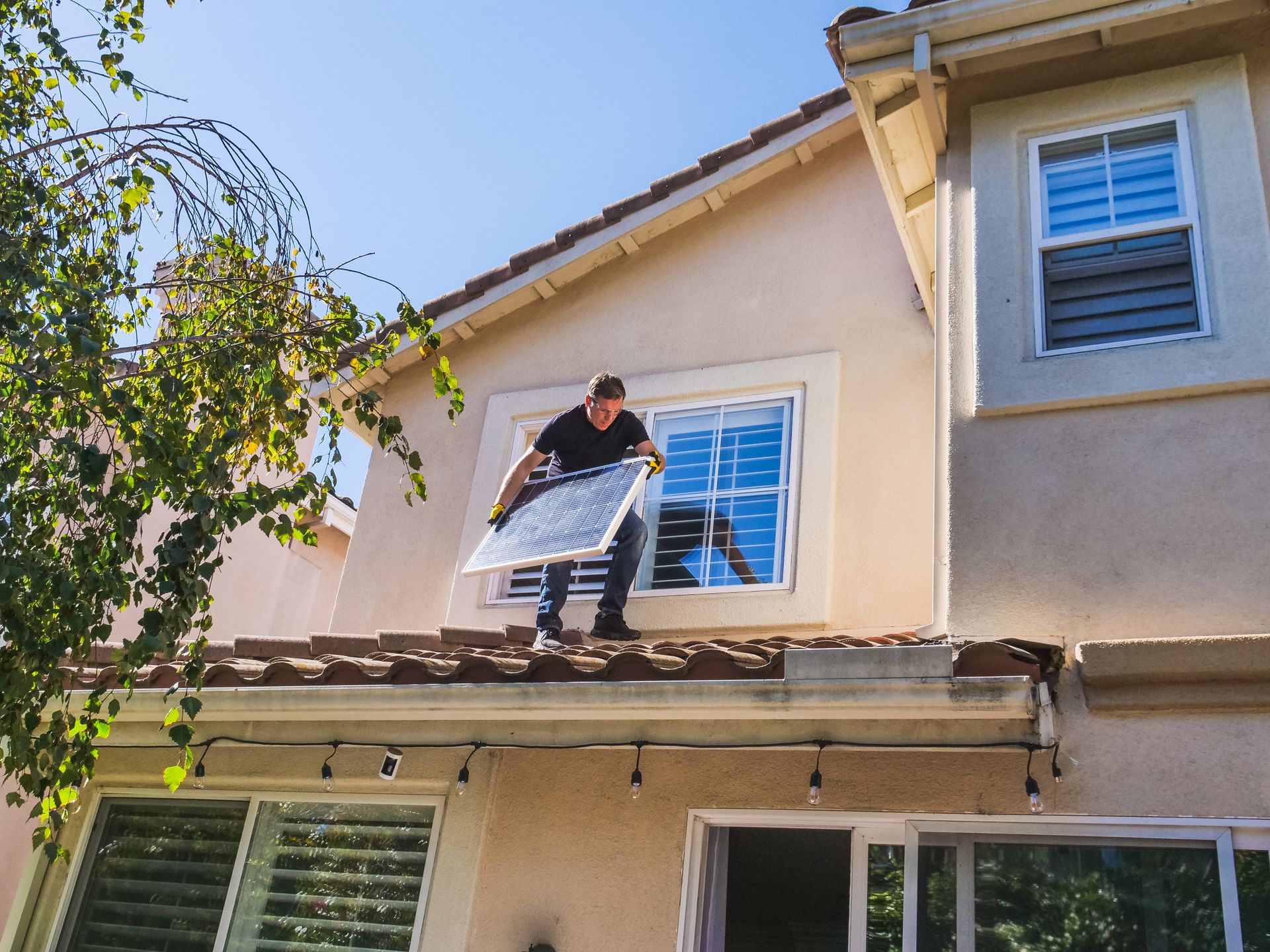 man on a roof installing solar panels